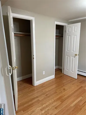 an empty room with wooden floor and closet