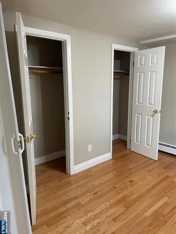 an empty room with wooden floor and closet