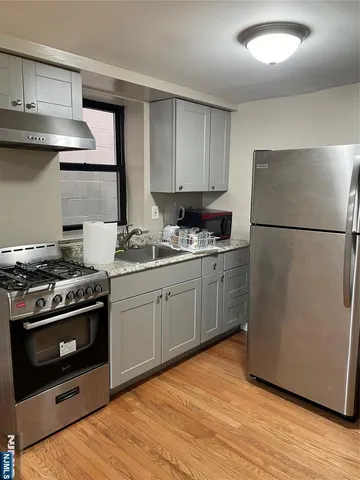 a kitchen with a stove a refrigerator and a sink