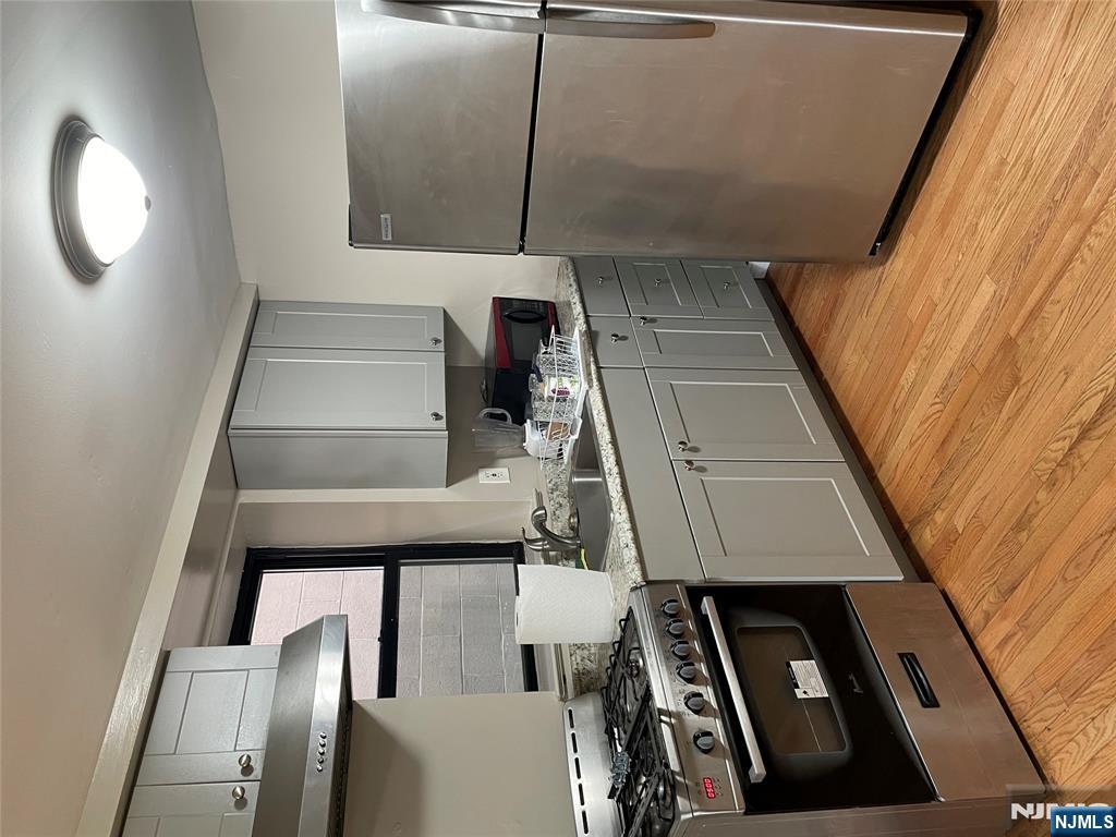 230 Anderson Avenue, Unit 1B Fairview, NJ 07022 - Photo 4 of 5 a kitchen with a stove a refrigerator and a sink
