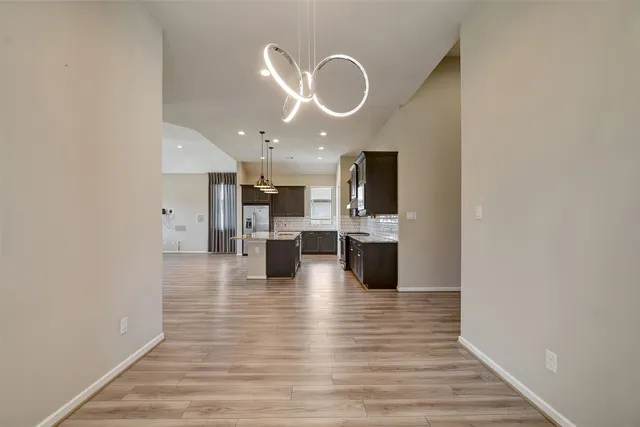 a view of kitchen dining table wooden floor and stainless steel appliances