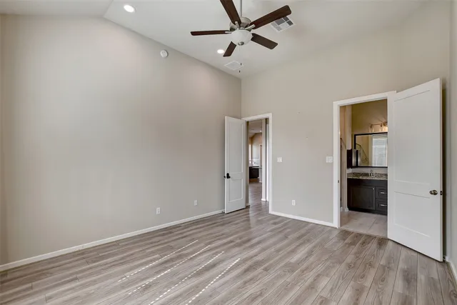 a view of a room with wooden floor and a ceiling fan