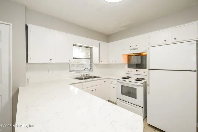 a kitchen with a sink a stove and refrigerator