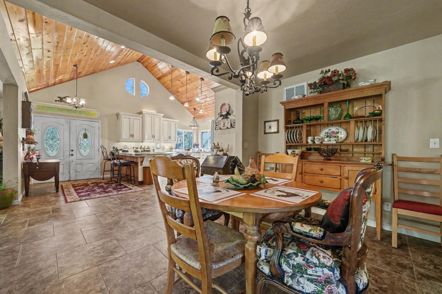 6145 Swiss Ranch Road Mountain Ranch, CA 95246 - Photo 25 of 84 a view of a dining room with furniture a chandelier and large windows