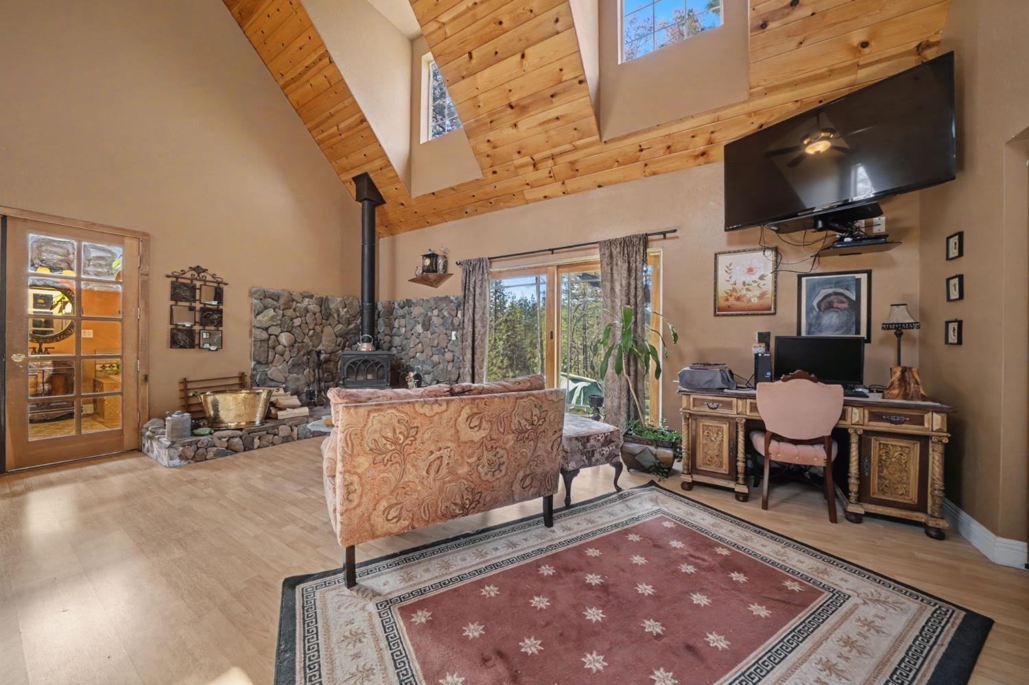 6145 Swiss Ranch Road Mountain Ranch, CA 95246 - Photo 34 of 84 a living room with furniture a flat screen tv and a floor to ceiling window