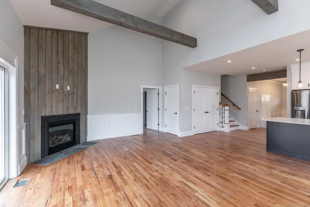 a view of empty room with wooden floor and fireplace