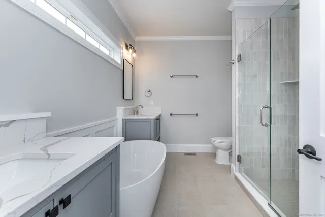 a bathroom with a sink a toilet and shower