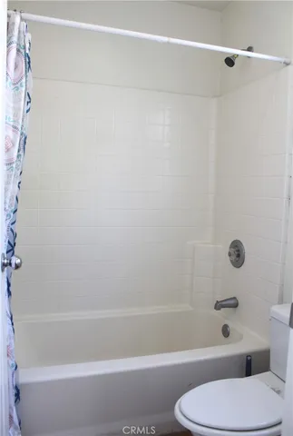 a bathroom with a toilet and a bath tub