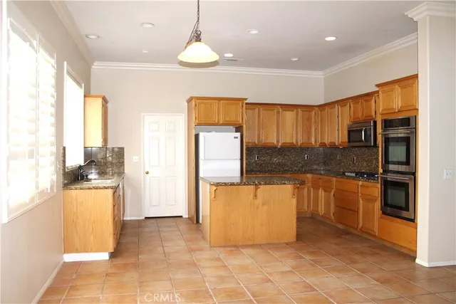 a kitchen with stainless steel appliances granite countertop a refrigerator and a stove top oven