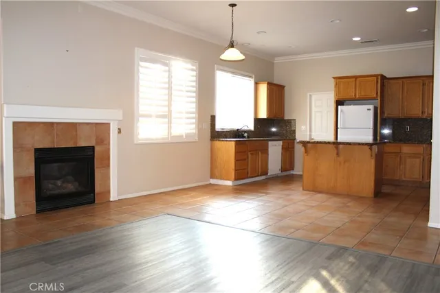 a view of a kitchen with a stove wooden cabinets and a living room