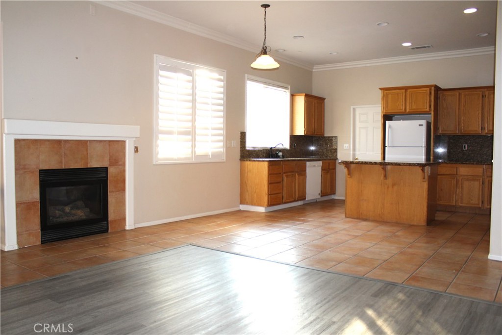 7881 Margaux Place Rancho Cucamonga, CA 91739 - Photo 9 of 41 a view of a kitchen with a stove wooden cabinets and a living room