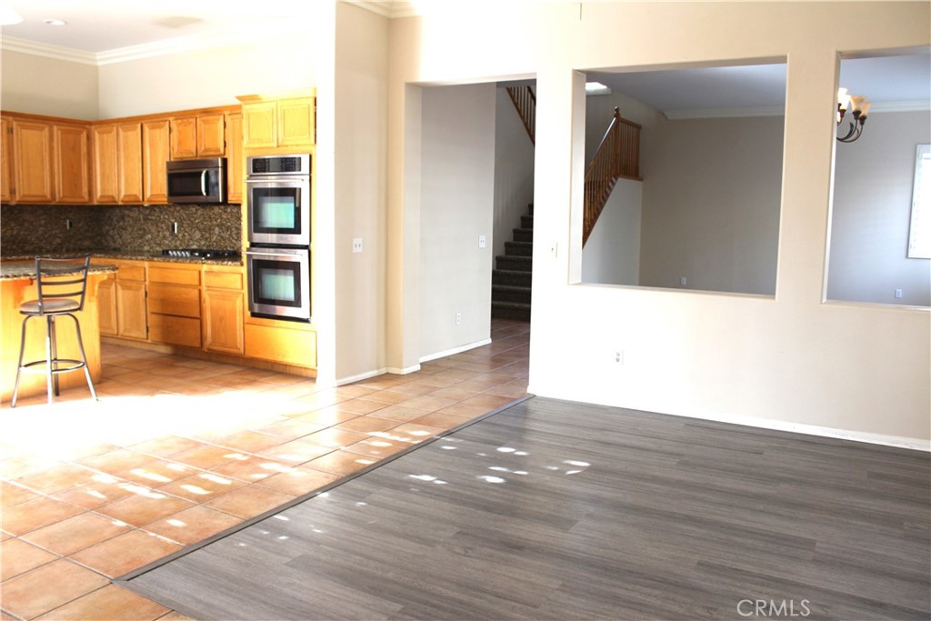 7881 Margaux Place Rancho Cucamonga, CA 91739 - Photo 10 of 41 a view of a kitchen with kitchen island granite countertop wooden floor and stainless steel appliances
