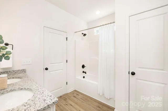 a bathroom with a granite countertop sink a shower and a mirror