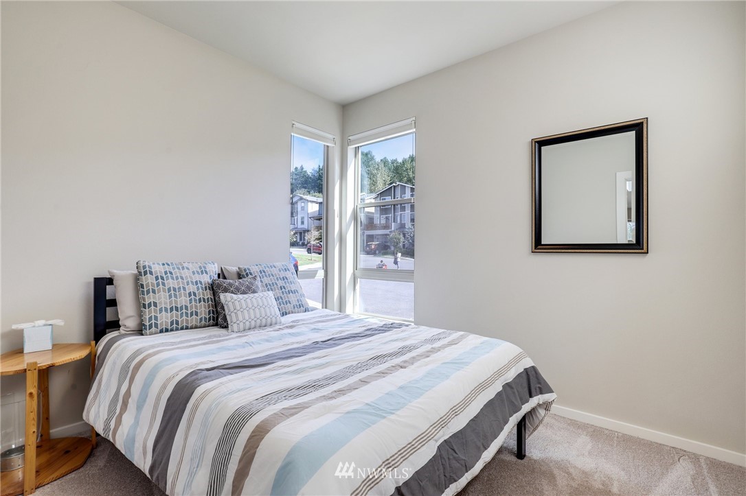 19237 97th Avenue South Renton, WA 98055 - Photo 3 of 29 a bedroom with a large bed and a lamp on dresser