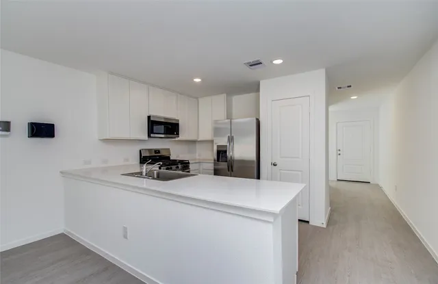 a kitchen with stainless steel appliances a refrigerator sink and microwave