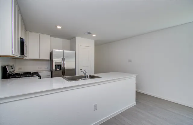 a kitchen with a sink a stove and refrigerator