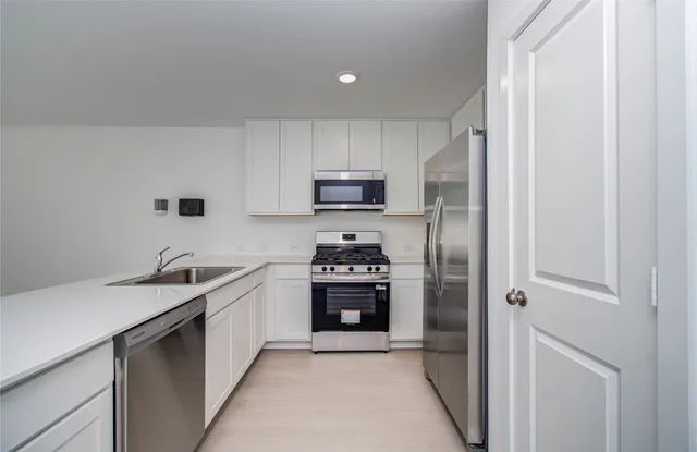 a kitchen with granite countertop a stove sink and refrigerator