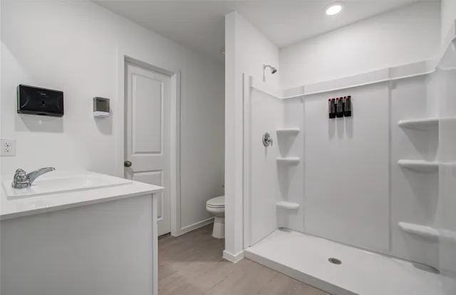 a bathroom with a sink a toilet and shower