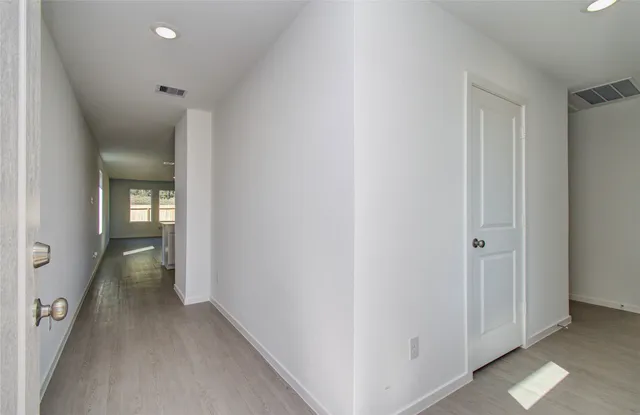 a view of a hallway with wooden floor