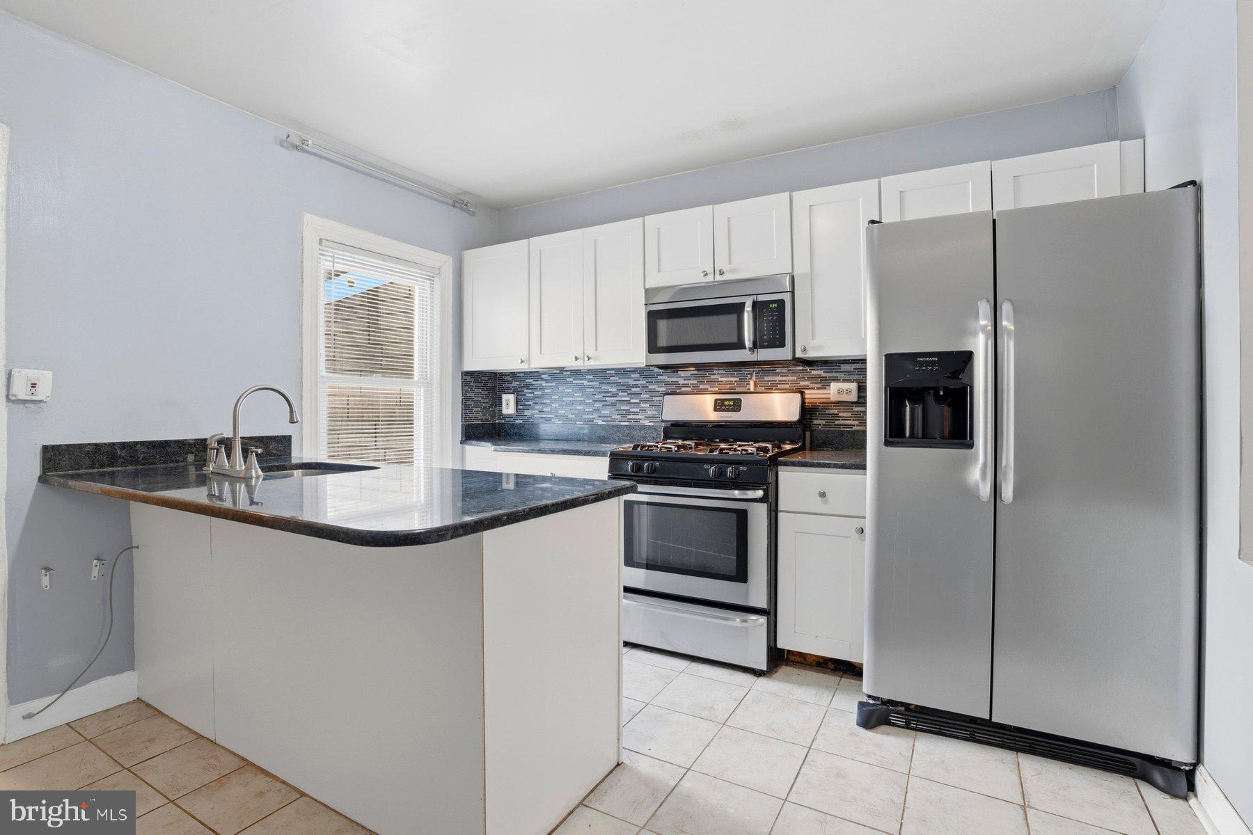12 West Randall Street Baltimore, MD 21230 - Photo 12 of 28 a kitchen with stainless steel appliances granite countertop a refrigerator sink and stove