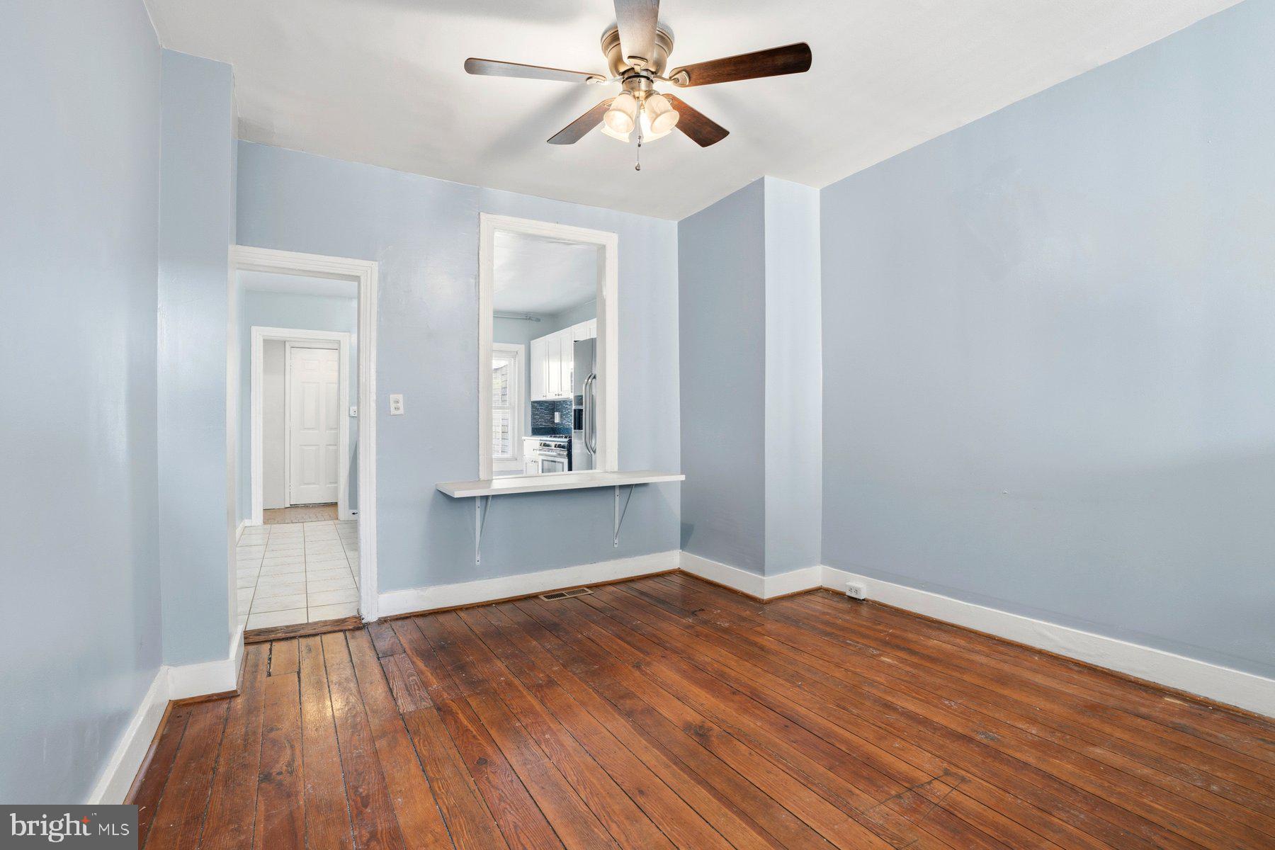 12 West Randall Street Baltimore, MD 21230 - Photo 2 of 28 an empty room with wooden floor chandelier fan and windows