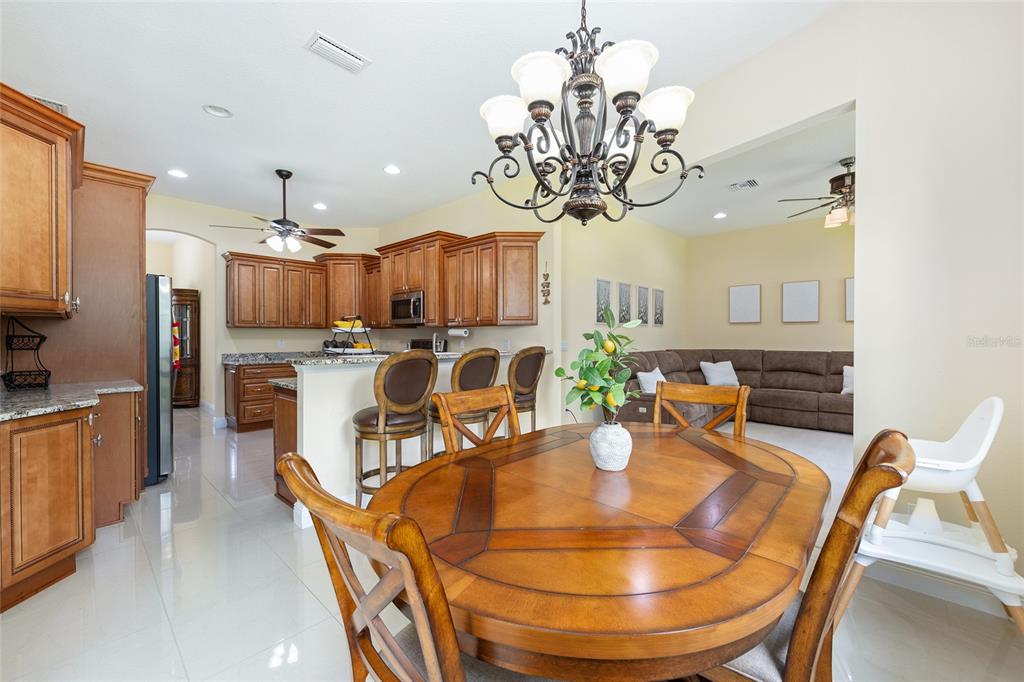 5024 Southwest 114th Street Road Ocala, FL 34476 - Photo 20 of 56 a dining room filled chandelier and kitchen view