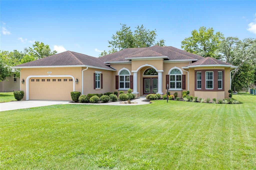 5024 Southwest 114th Street Road Ocala, FL 34476 - Photo 3 of 56 a front view of a house with a yard