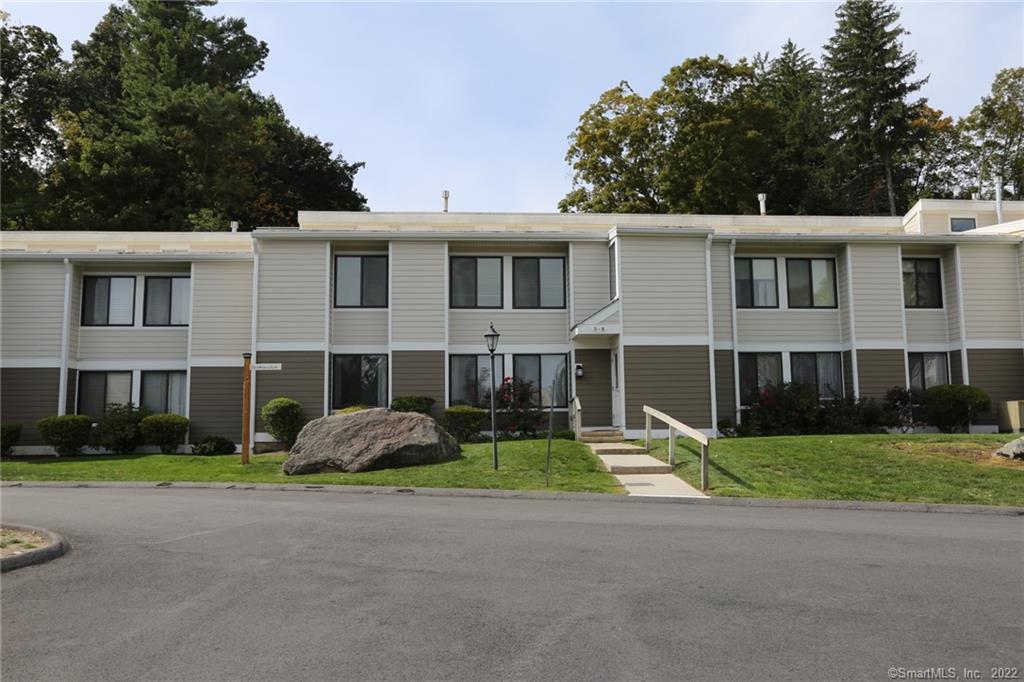 7 Stebbins Close, Unit 7 Ridgefield, CT 06877 - Photo 1 of 1 a front view of residential houses with yard and trees