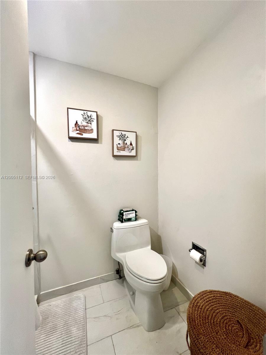 8114 Southwest 81st Terrace Miami, FL 33143 - Photo 11 of 20 a bathroom with a toilet a sink and mirror