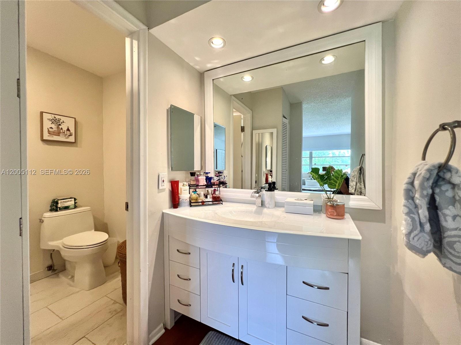 8114 Southwest 81st Terrace Miami, FL 33143 - Photo 12 of 20 a bathroom with a sink a toilet and a mirror