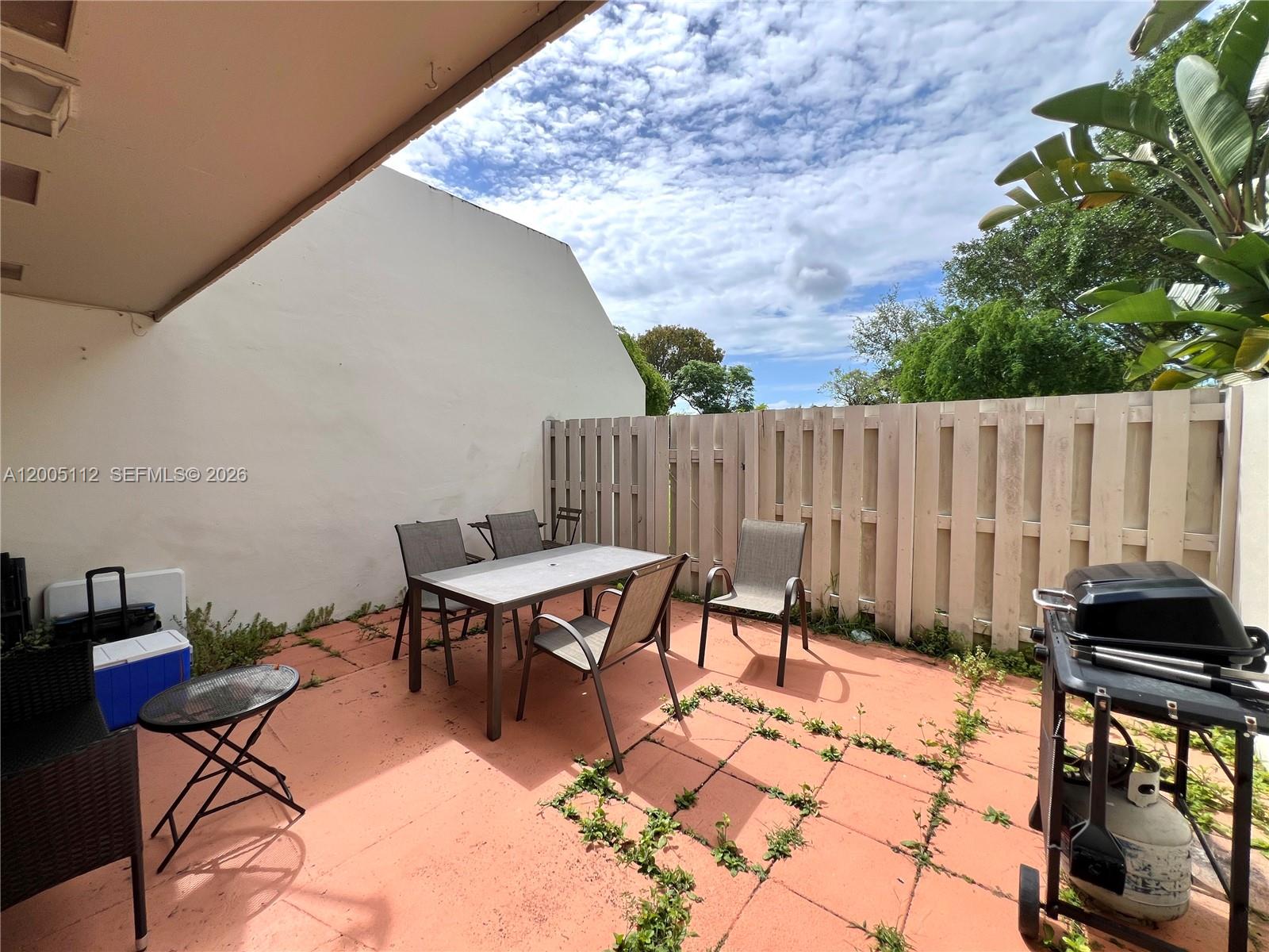 8114 Southwest 81st Terrace Miami, FL 33143 - Photo 19 of 20 a backyard of a house with table and chairs