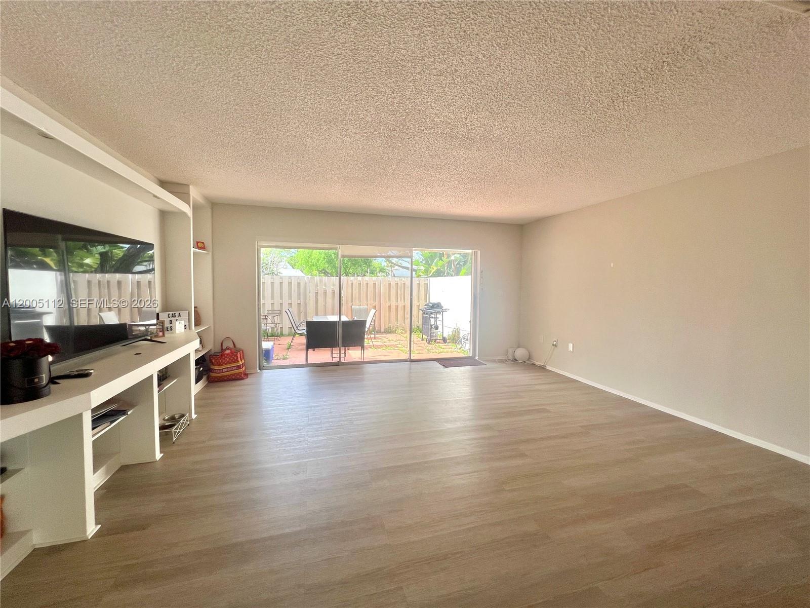 8114 Southwest 81st Terrace Miami, FL 33143 - Photo 7 of 20 an empty room with wooden floor and windows