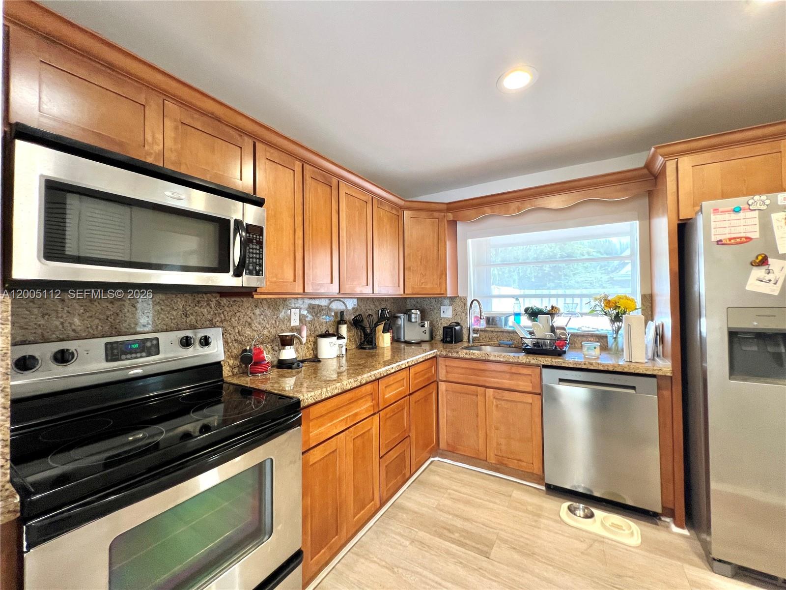 8114 Southwest 81st Terrace Miami, FL 33143 - Photo 9 of 20 a kitchen with stainless steel appliances a stove sink microwave and cabinets