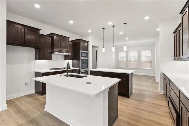 a kitchen with stainless steel appliances a sink and a refrigerator