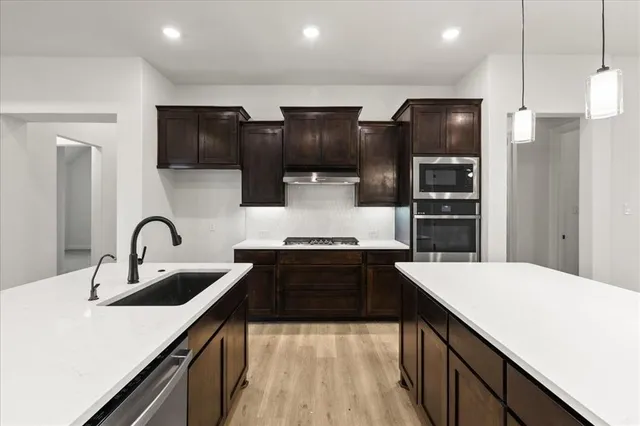 a kitchen with a sink and stainless steel appliances