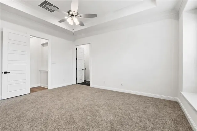 an empty room with a ceiling fan and a window