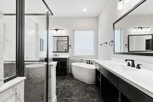 a bathroom with a double vanity sink mirror and bathtub
