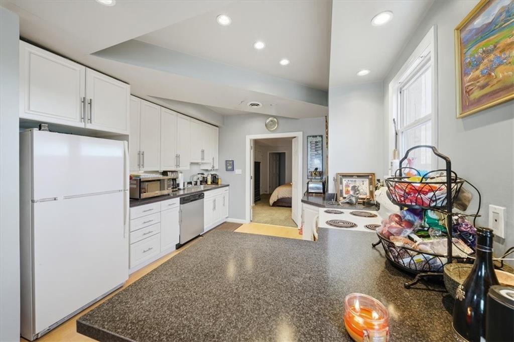 237 Grandview Avenue Pittsburgh, PA 15211 - Photo 18 of 43 a kitchen with stainless steel appliances kitchen island granite countertop a refrigerator and a sink
