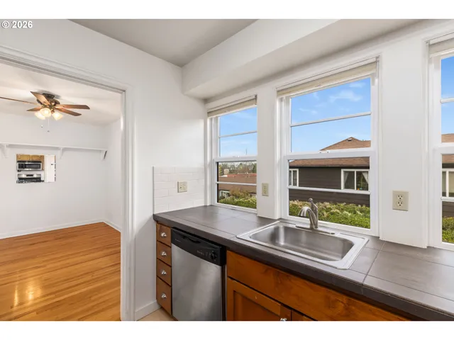 a kitchen view with granite countertop a sink and a wooden floor