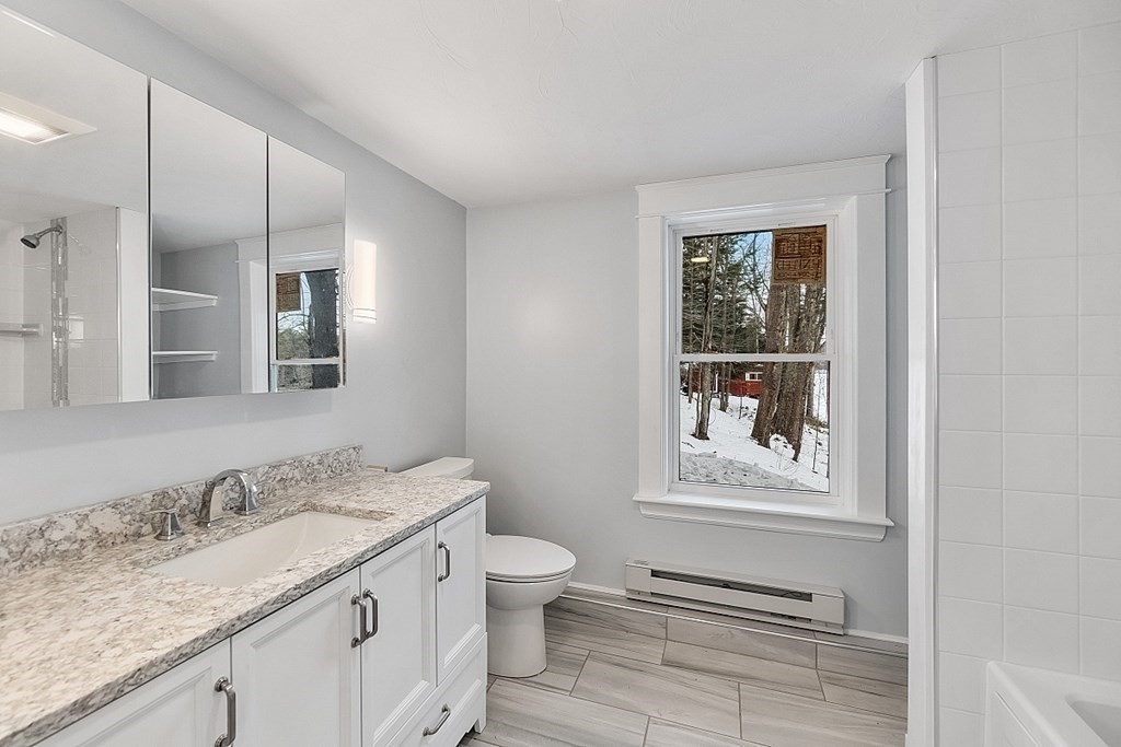 37 Watatic Pond Road Ashburnham, MA 01430 - Photo 25 of 42 a bathroom with a granite countertop sink a toilet and a window
