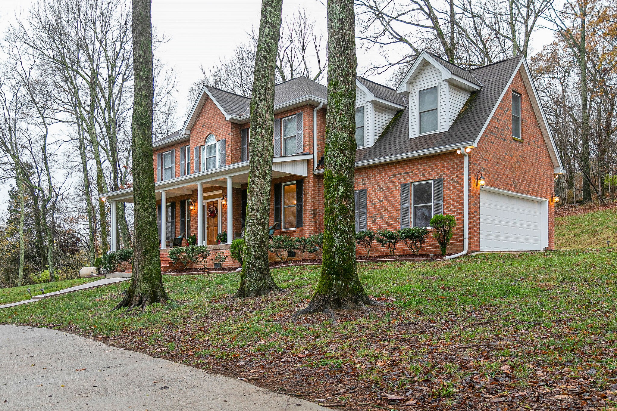 4311 Peytonsville-Trinity Road Franklin, TN 37064 - Photo 3 of 32 a view of a brick house with a yard and large trees