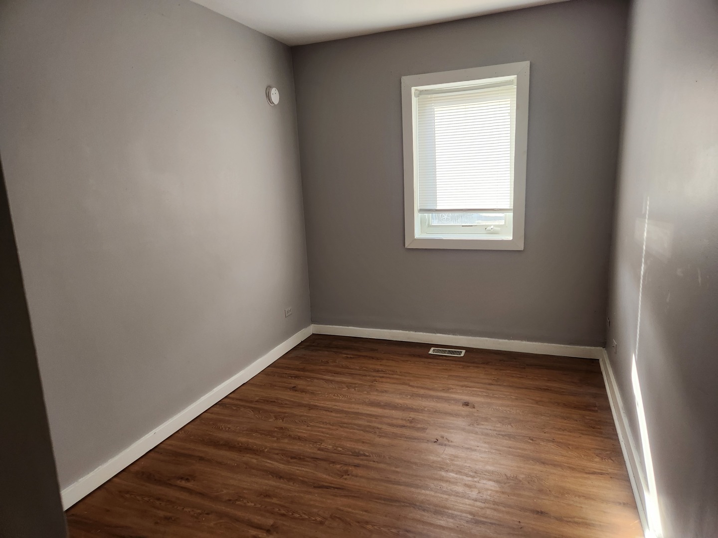 106 West Comanche Avenue, Unit 1E Shabbona, IL 60550 - Photo 7 of 9 a view of an empty room with wooden floor and a window