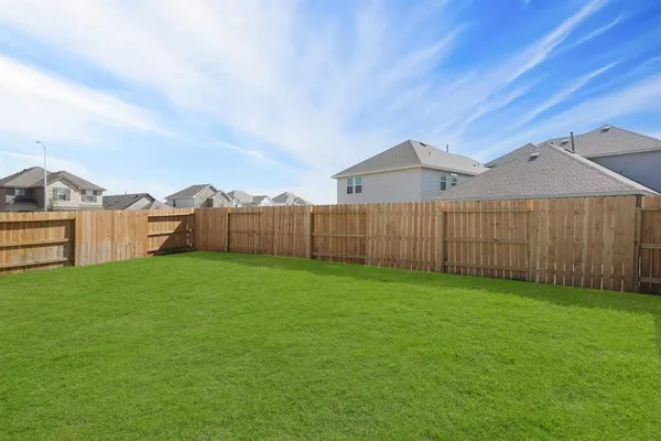a view of a backyard with wooden fence