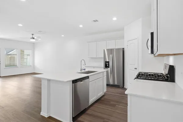 a kitchen with stainless steel appliances granite countertop a sink stove and refrigerator