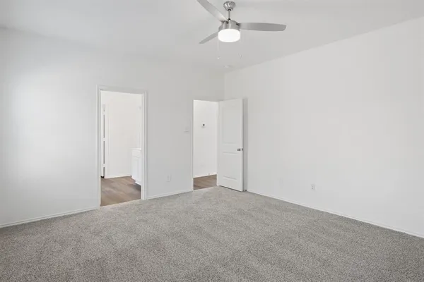 an empty room with a ceiling fan and a window