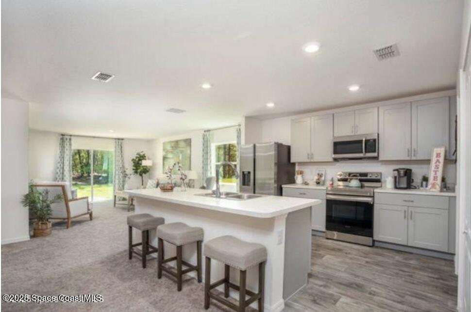 1190 Sandusky Street Southeast Palm Bay, FL 32909 - Photo 2 of 11 a large kitchen with kitchen island granite countertop lots of counter space a sink appliances and cabinets