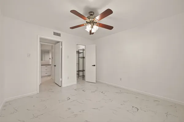 an empty room with a ceiling fan and a window