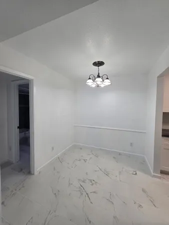 an empty room with a chandelier fan