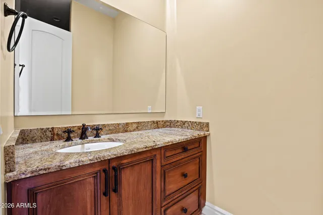 a bathroom with a granite countertop sink and a mirror