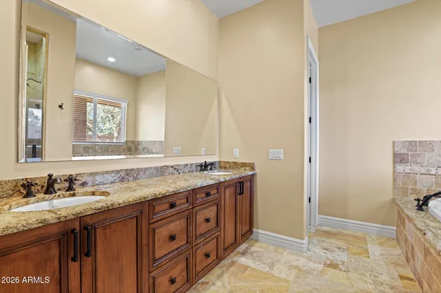 a bathroom with a granite countertop sink and a mirror